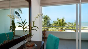 A room with a view of the ocean, a potted plant, and a chair. - The Beach Apartments (Negombo)
