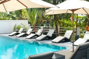 Una piscina al aire libre, tumbonas