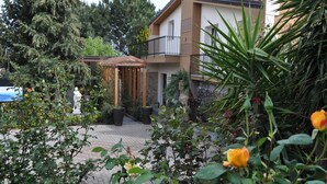 Une cour avec un kiosque, des plantes en pot et une statue.