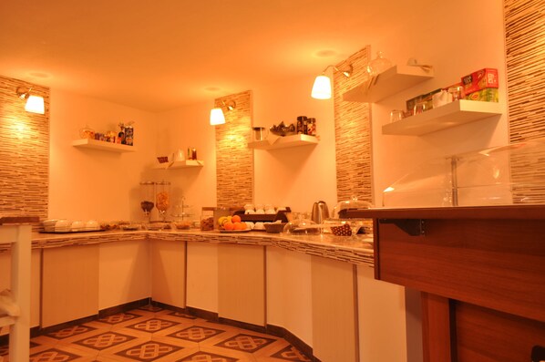 A kitchen with a wooden countertop, white cabinets, and shelves with kitchen items. - Agri Art Croce Vallone (Biancavilla)