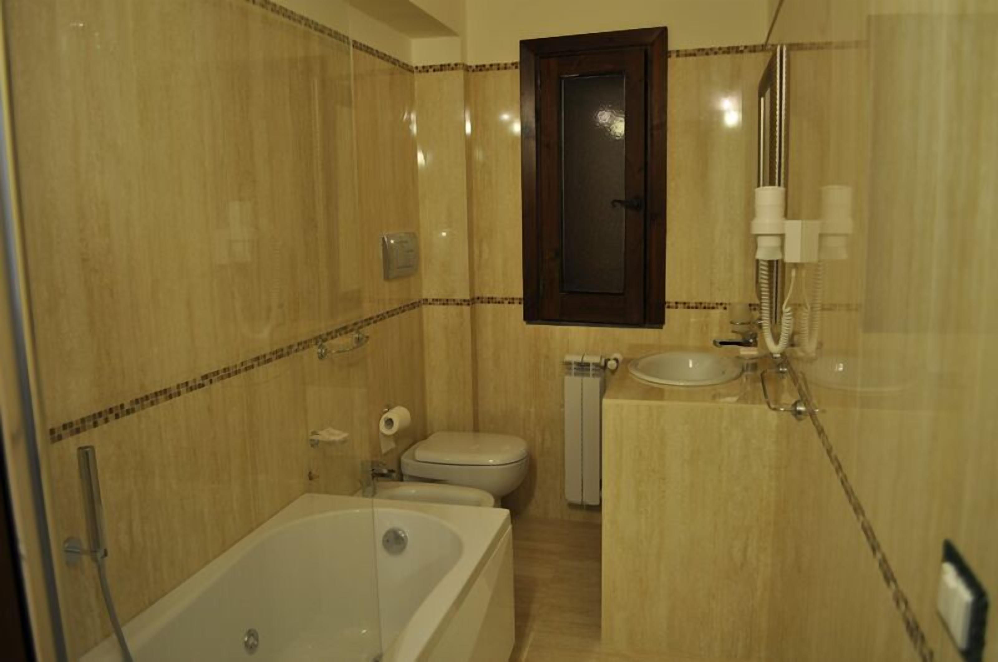 A bathroom with a bathtub, toilet, and sink.