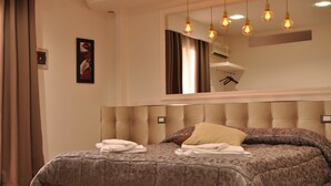 Une chambre à coucher avec un grand lit, une tête de lit dotée d’un éclairage intégré et un miroir au-dessus du lit.