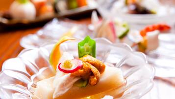 A close-up of a glass plate with a food item garnished with radish and green pepper.