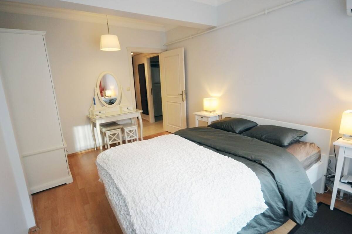 Una camera da letto con un letto, comodini, uno specchio e un armadio.