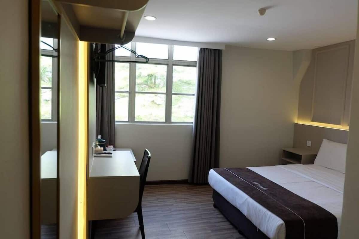Une chambre d’hôtel avec un lit, un bureau et une chaise.