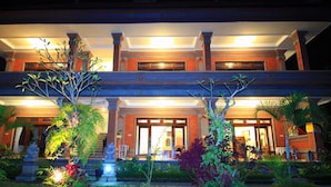 A two-story building with a central entrance, surrounded by lush greenery and a well-lit facade. - Tanah Semujan Ubud (Ubud)