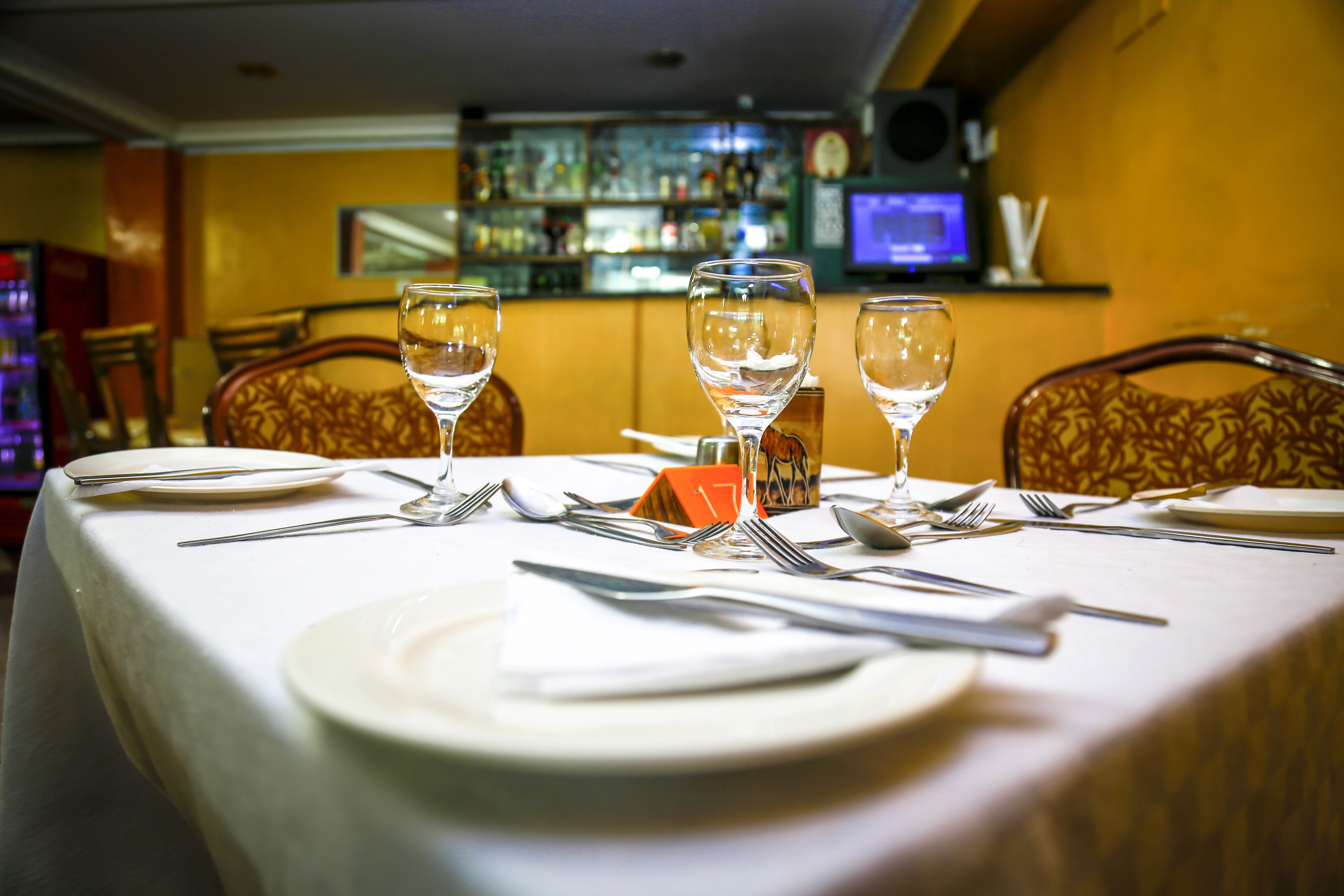A table set for dining with a bar in the background.