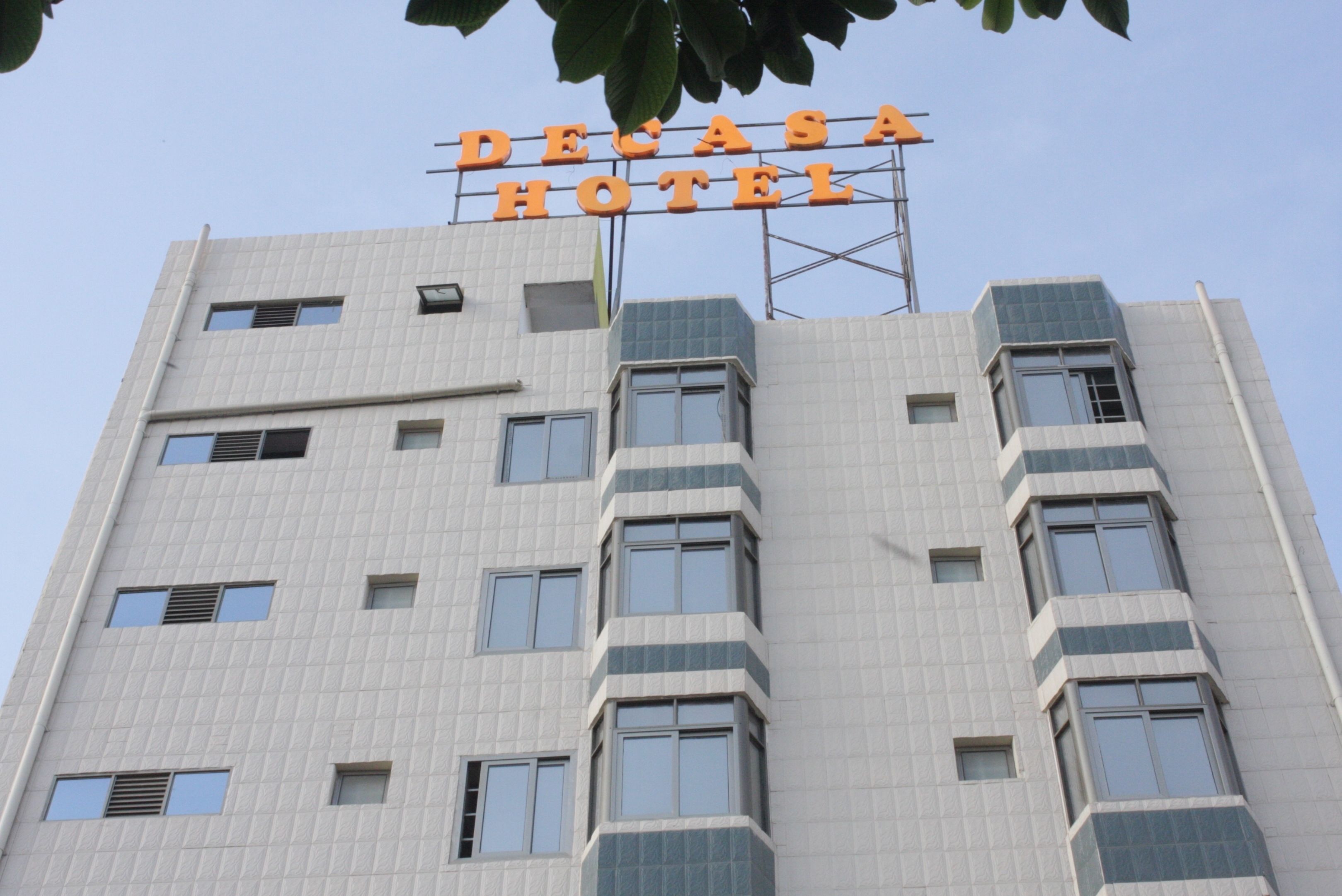A hotel named Decasa Hotel with a modern architectural design, featuring multiple windows and balconies.