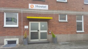A hostel with a signboard, a door with a number, and two potted plants. - GZ Hostel Bonn (Bonn)