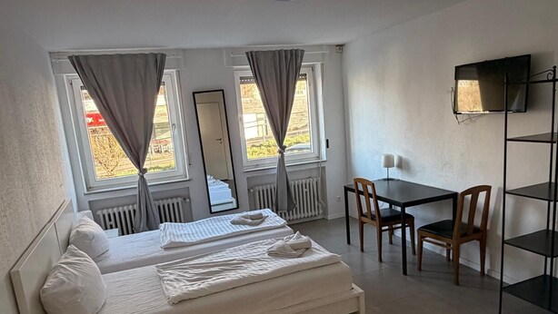 Une chambre d’hôtel avec un lit, un bureau et une télévision.