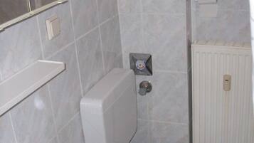 A bathroom with a white sink, toilet, and a mirror.