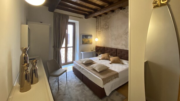 Une chambre à coucher avec un grand lit, une chaise, un bureau et un miroir.