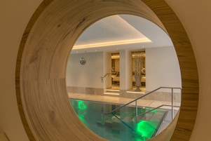 Una piscina techada, sillones reclinables de piscina