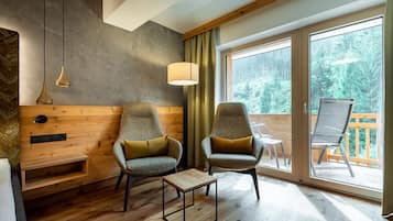 Suite junior, balcón | Área de sala de estar | Televisión de pantalla plana de 32 pulgadas con canales por cable