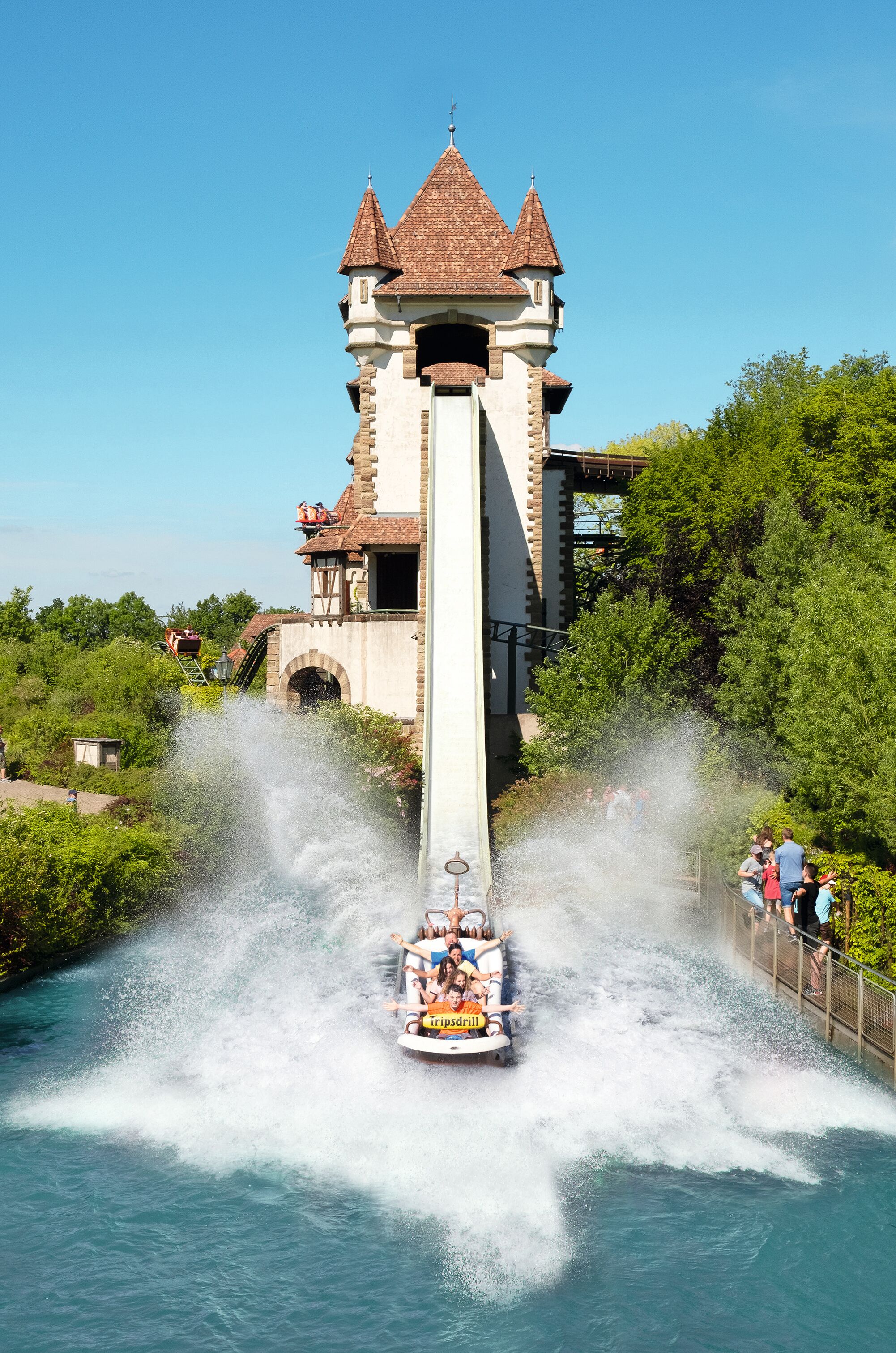 A water ride with a castle-like structure in the background.