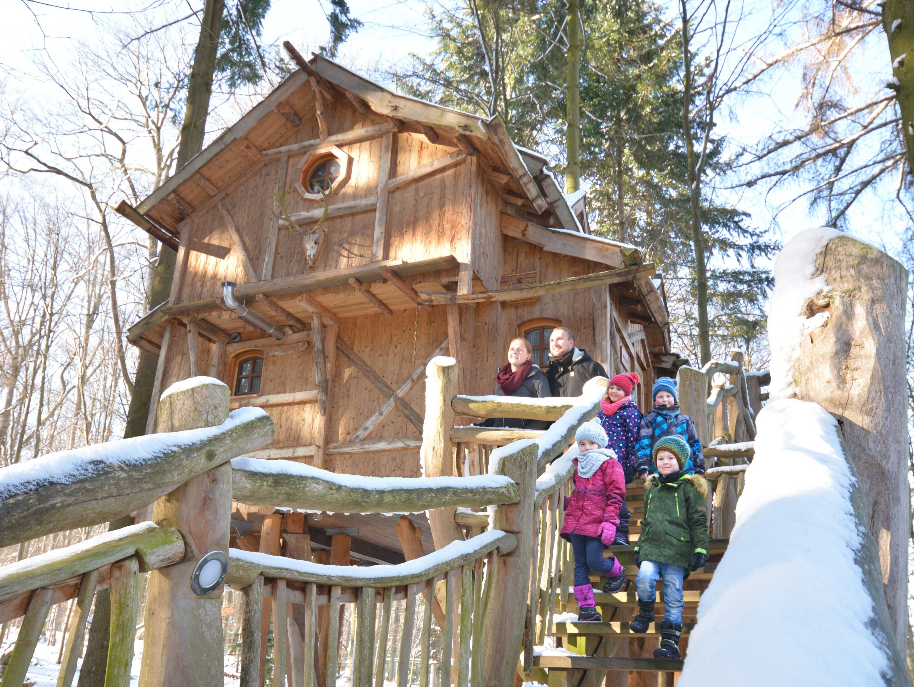 A wooden cabin with a spiral staircase leading to a balcony.