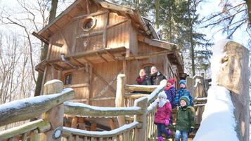 A wooden cabin with a spiral staircase leading to a balcony.