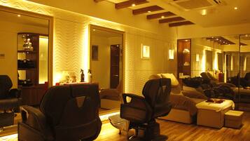 A modern interior with a seating area, a massage chair, and a mirror reflecting the room.