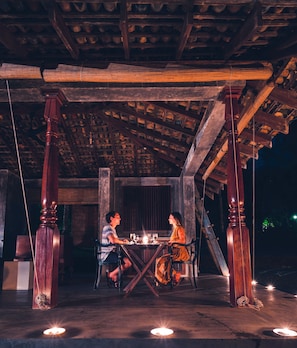 A wooden dining area with a table and chairs, under a roof with exposed beams. - The River House by Asia Leisure (Balapitiya)