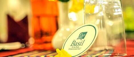 Una botella etiquetada 'Basil Park' con una flor amarilla a su lado.