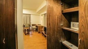 A wooden cabinet with a radio, a wooden floor, and a chair in the background.