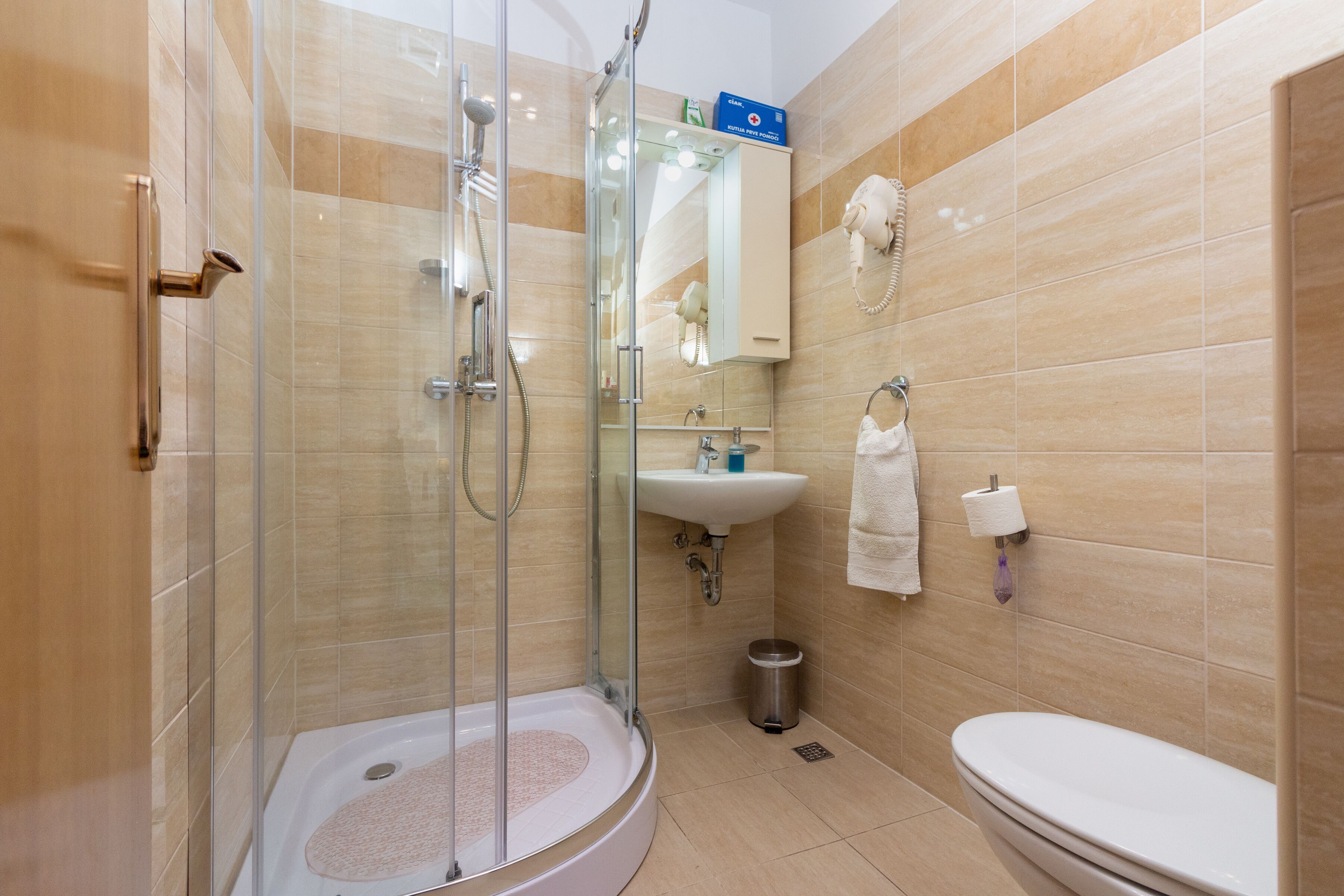 A modern bathroom with a glass-enclosed shower, a sink, and a toilet.