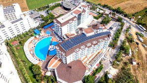 Ein Hotel mit mehreren Gebäuden, einem Schwimmbad und einem Tennisplatz.
