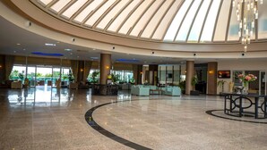 Eine großzügige Lobby mit hoher Decke und Oberlichter, ausgestattet mit einer Rezeption, Sitzbereichen und einem großzügigen, offenen Grundriss.