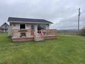 A single-story house with a front porch, a small deck, and a visible number '10' on the door.