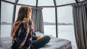 Una habitación con cama, ventana y vistas a un paisaje nevado.