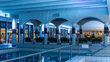 Swimmers can enjoy a refreshing dip in the pool surrounded by a series of arches and columns.