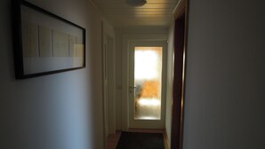 A narrow hallway with a dark carpet, a framed artwork on the left wall, and a door with frosted glass at the end. -  Hostel Bregenz  (Bregenz)