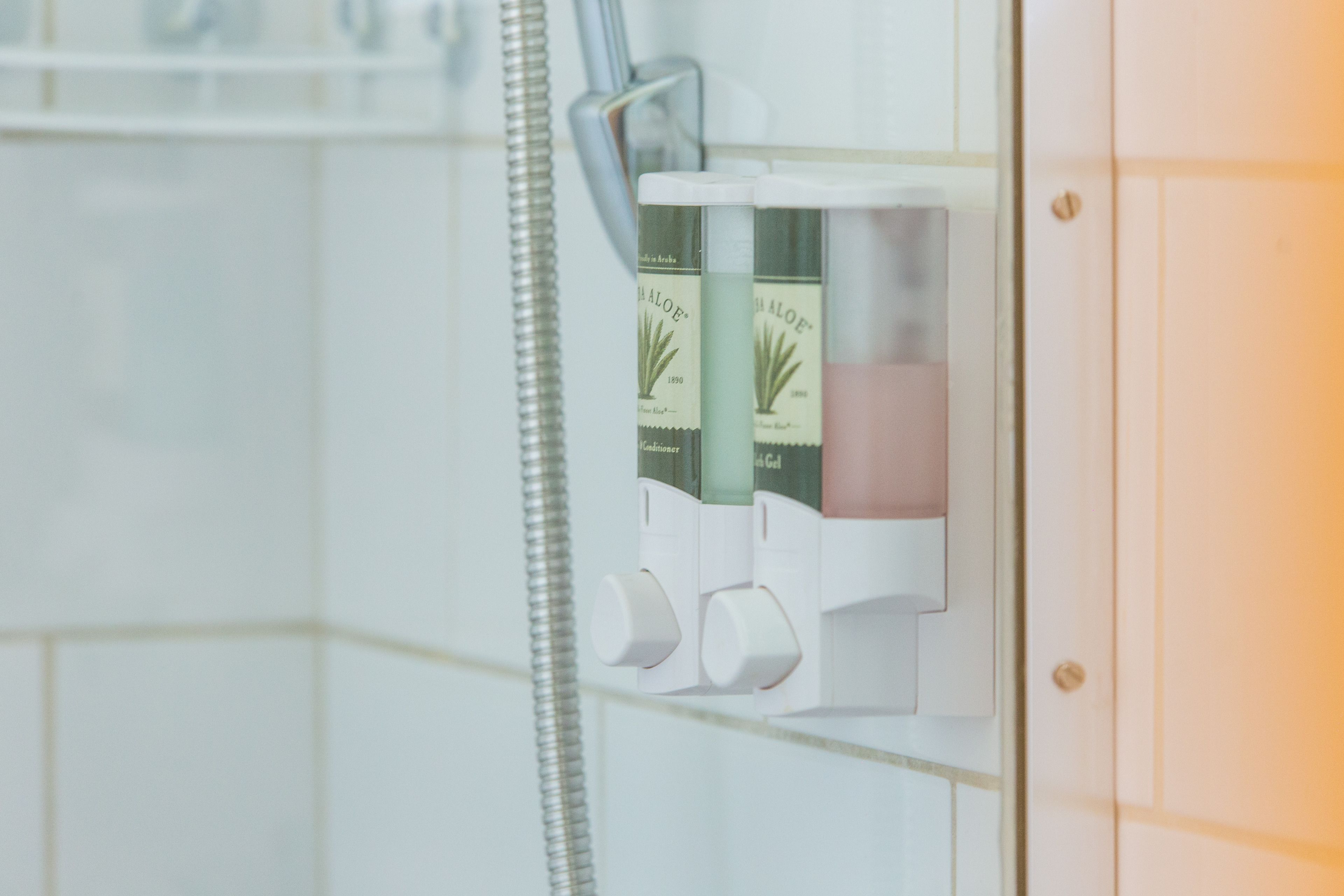 A shower control panel with multiple shower heads and a handheld shower attachment.