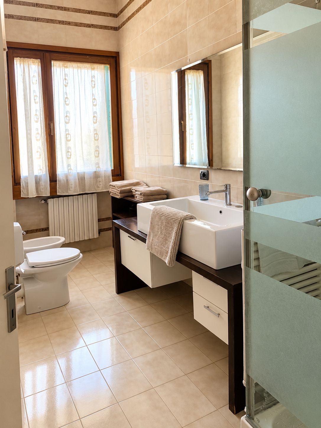 Un baño con inodoro, lavabo y espejo.