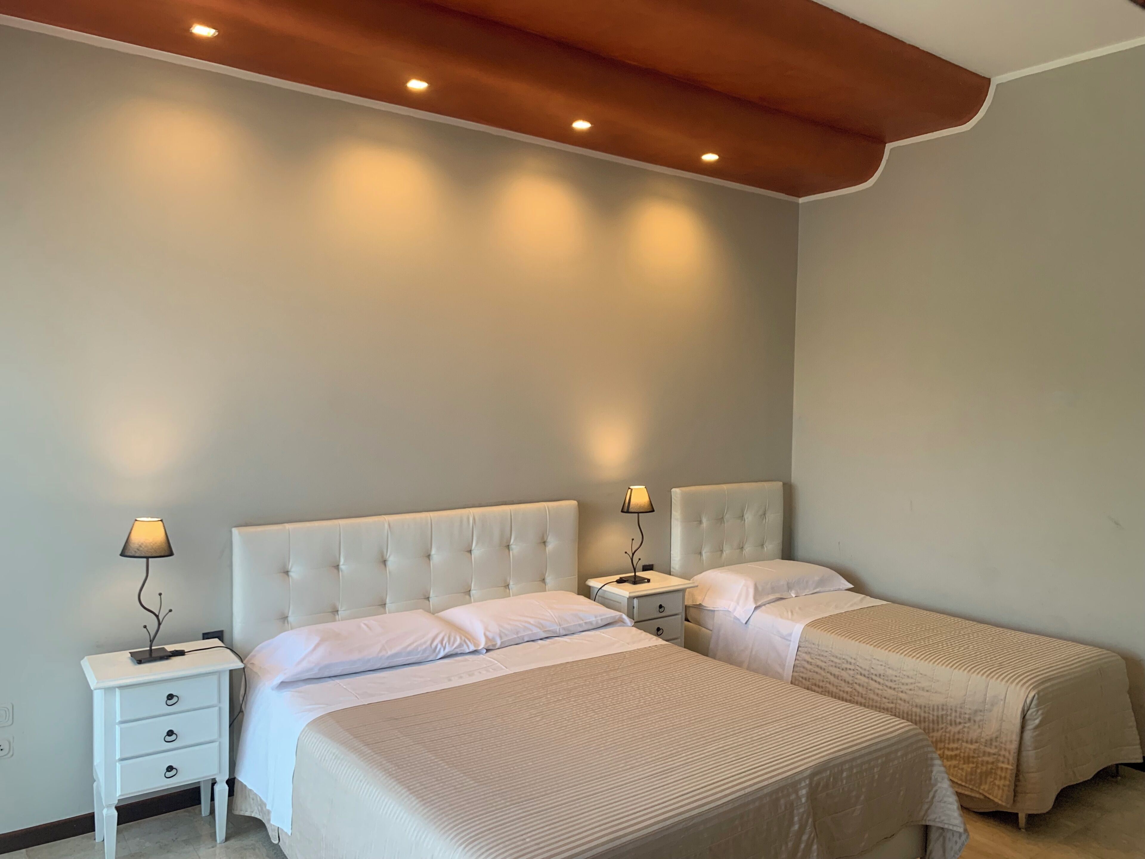 Une chambre avec deux lits, un plafond en bois et des lampes de chevet.