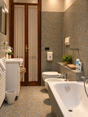 Un baño con bañera, inodoro, lavamanos y cortina de ducha.