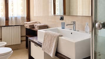 Ein modernes Badezimmer mit einem großen Waschbecken, einem Spiegel und einer Toilette.