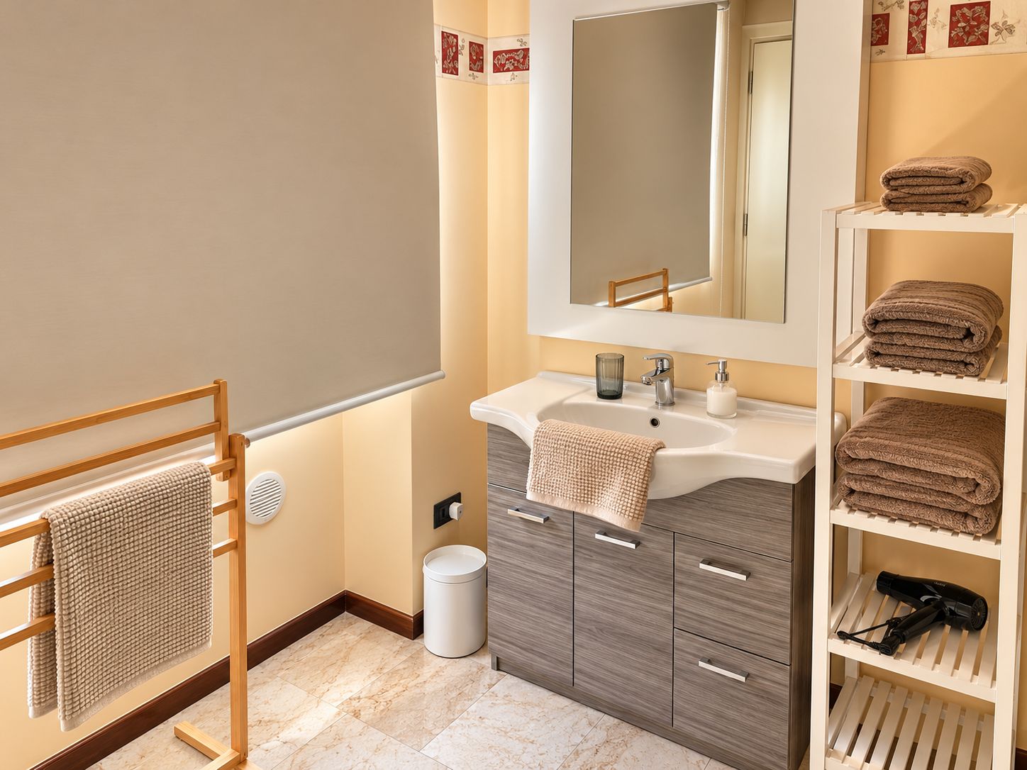 A modern bathroom with a vanity, a towel rack, and a shelf with towels and a hairdryer.