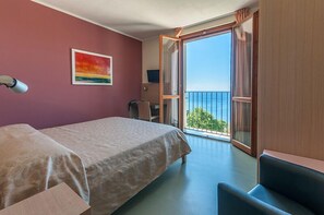 A room with a bed, a desk, a chair, and a balcony with a view. - Hotel Oroverde (Bergeggi)