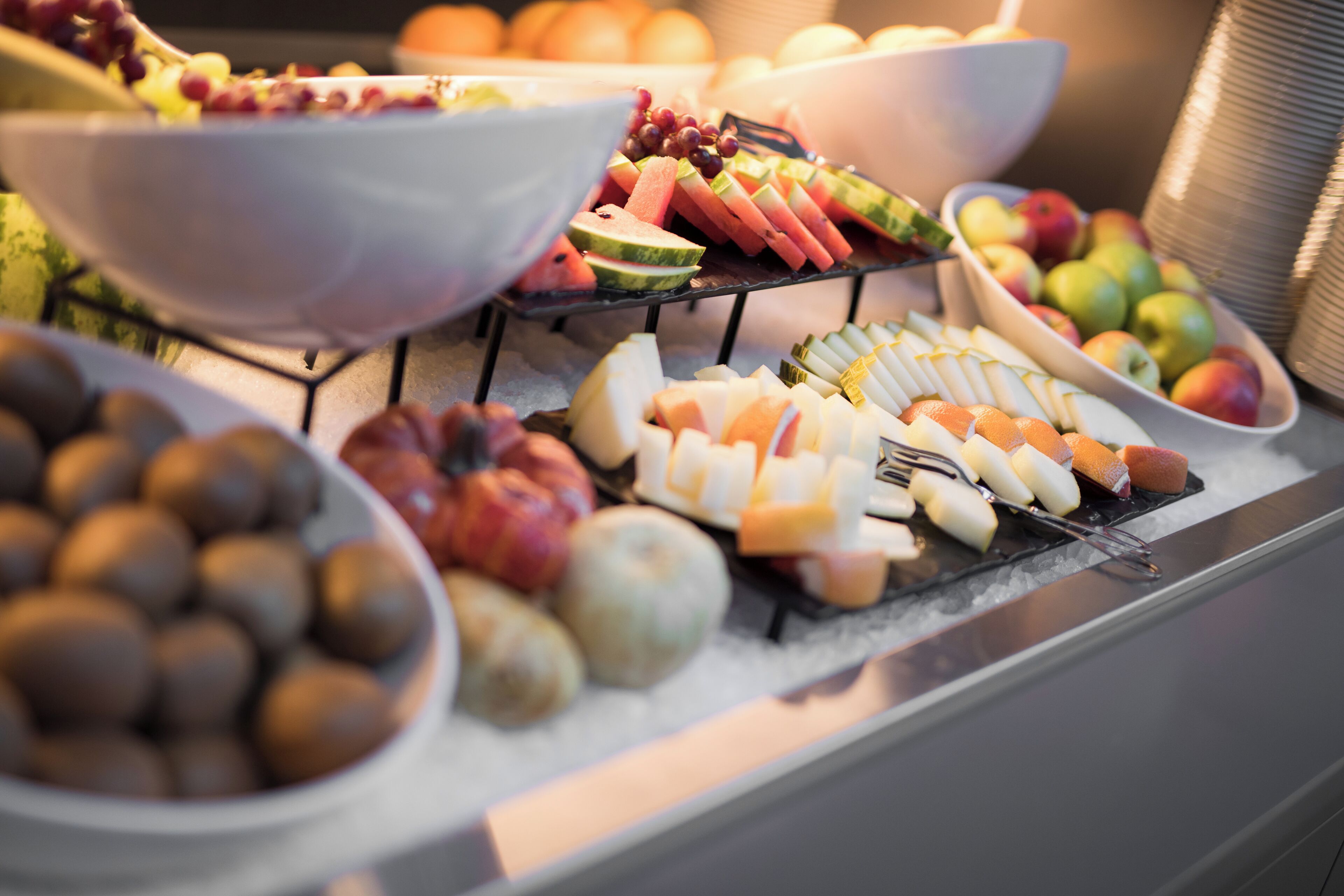A buffet with various fruits and cheeses.