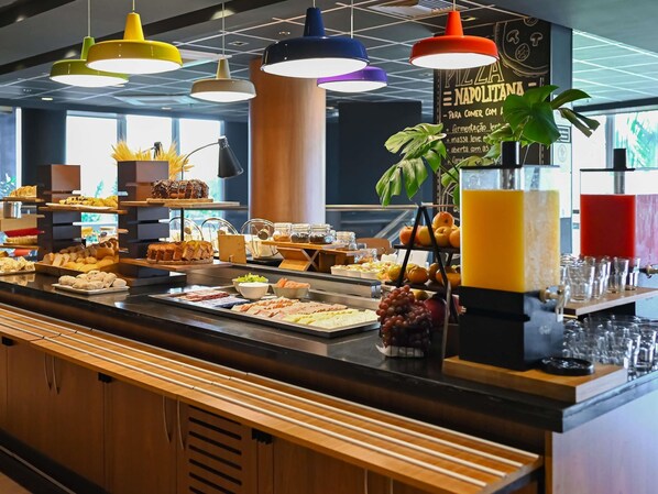 A buffet with various food items and a juice dispenser.