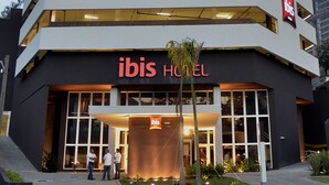 A modern hotel with a prominent 'ibis' sign, multiple floors, and a well-lit entrance. - Ibis Jundiai Shopping (Jundiai)