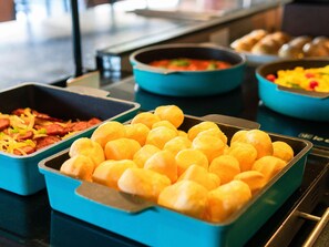 Indulge in a sumptuous spread of breakfast favorites, including scrambled eggs, savory dishes, and fresh bread.