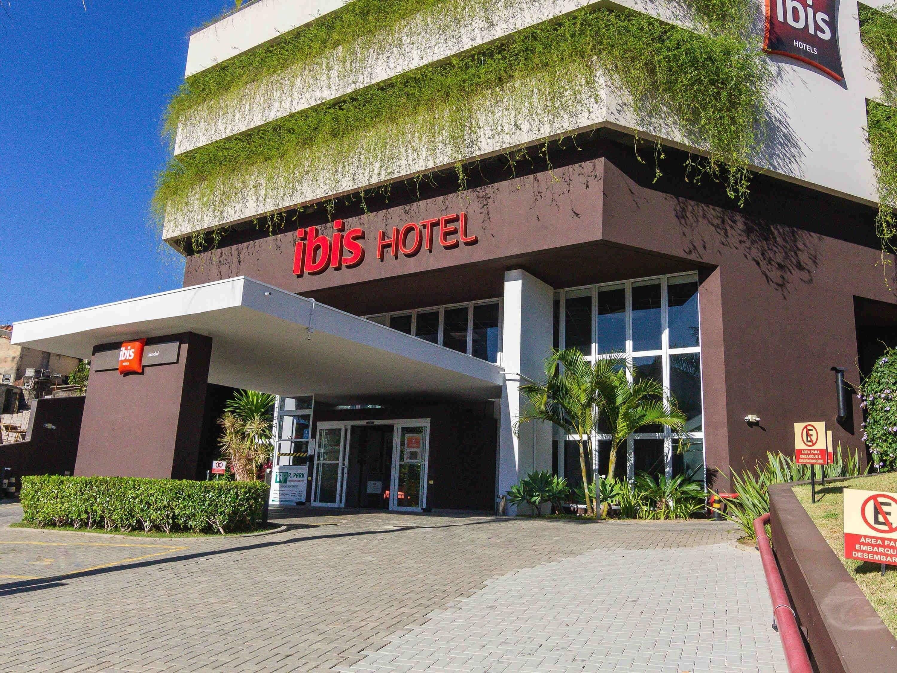 The exterior of the ibis hotel with a modern design, including a flat roof and large windows.