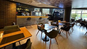 A restaurant interior with a bar area, seating arrangements, and a pizza bar. - Ibis Jundiai Shopping (Jundiai)