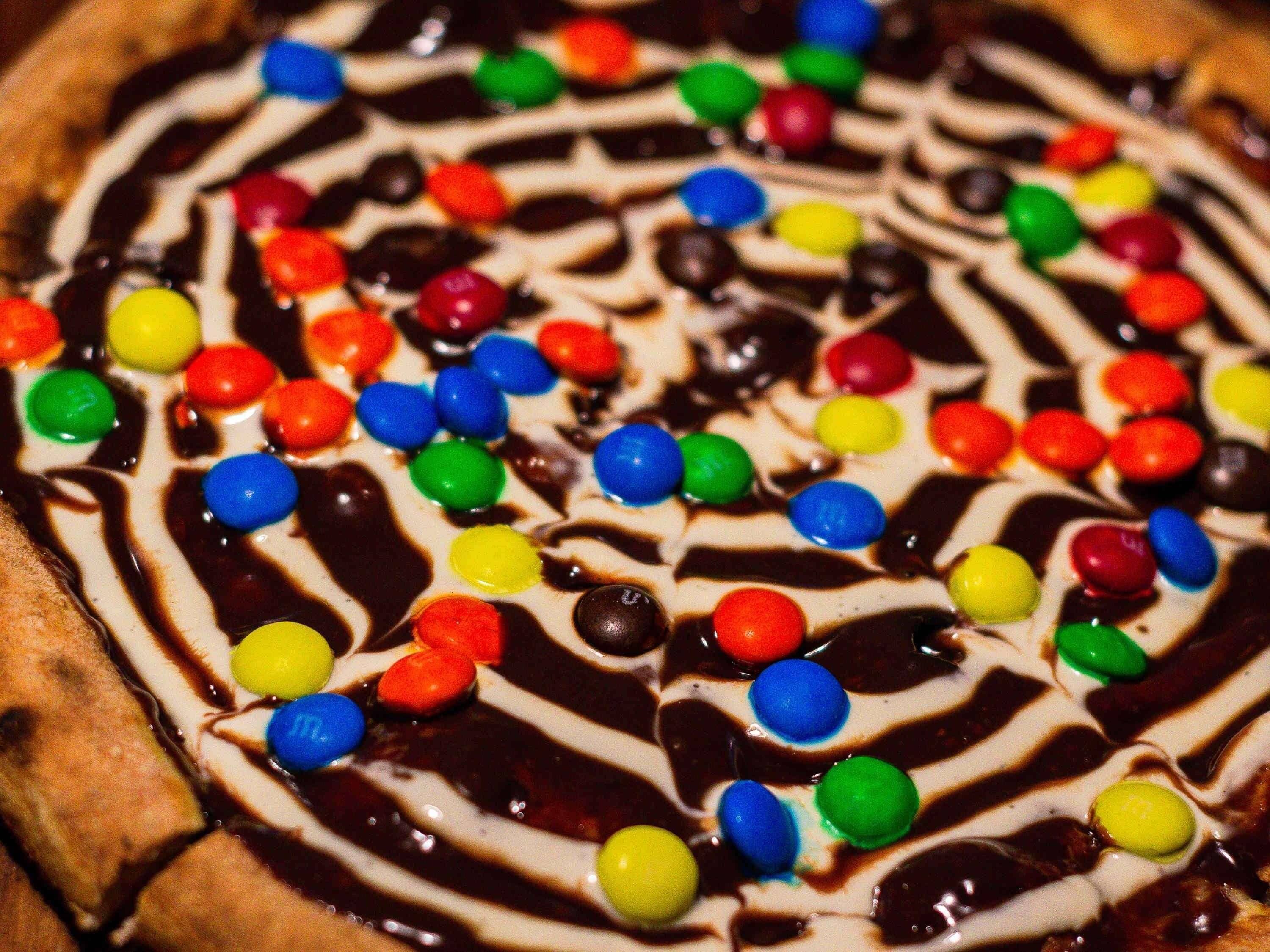 A dessert with colorful candy pieces and chocolate drizzle.