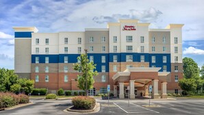 A multi-story hotel with a prominent Hampton Inn & Suites sign, a parking lot, and a landscaped entrance area. - Hampton Inn & Suites Fort Mill (Fort Mill)