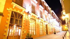A historic building with large windows and a wooden door, featuring a balcony and a sign that reads "COMERIO." - Hotel Palacio de Oñate Spa (Guadix)