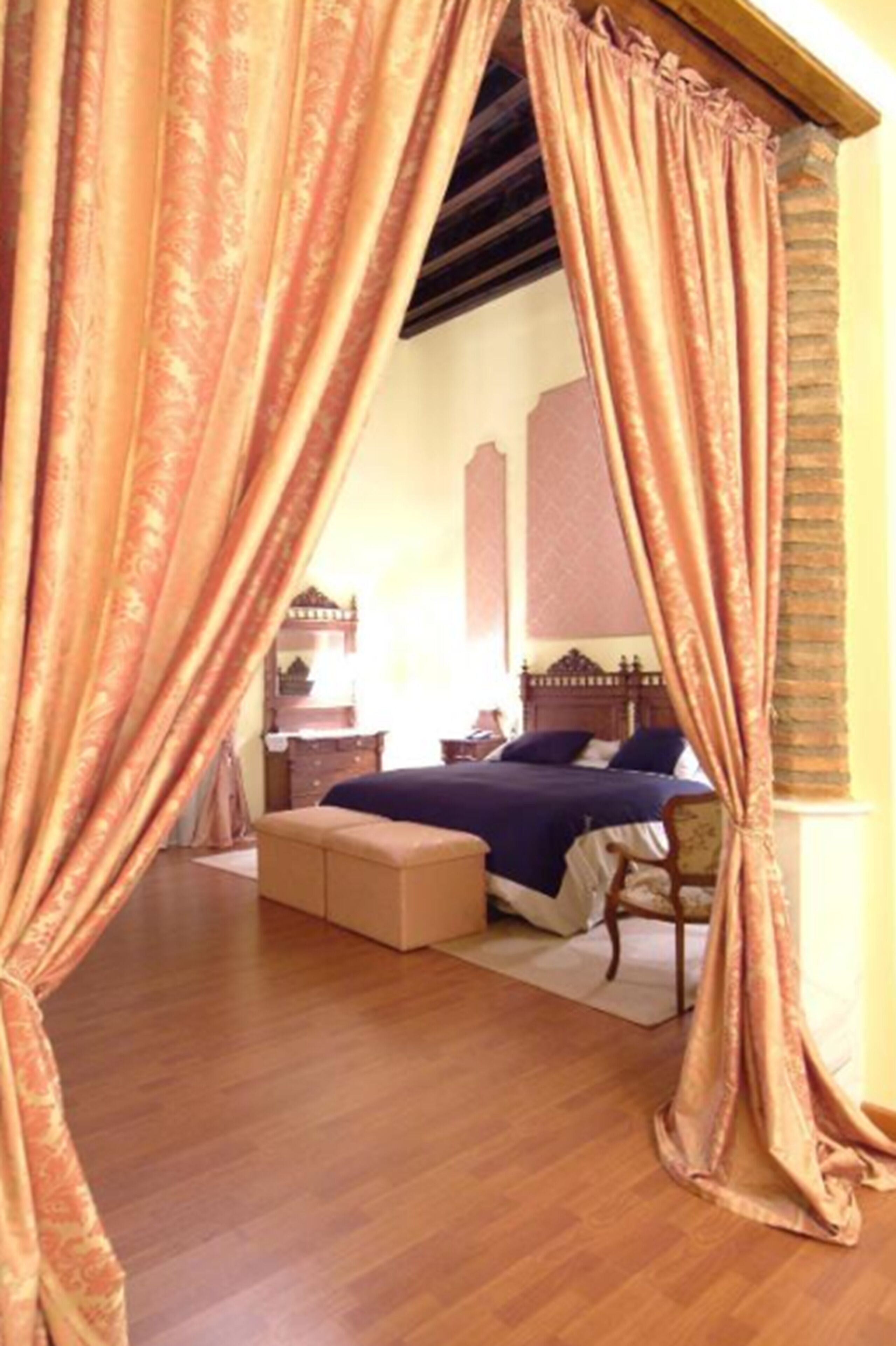 Un dormitorio con cama, mesita de noche y suelo de madera.