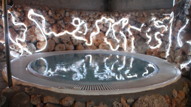 A stone-walled hot tub with a clear view of the interior. - Hotel Palacio de Oñate Spa (Guadix)
